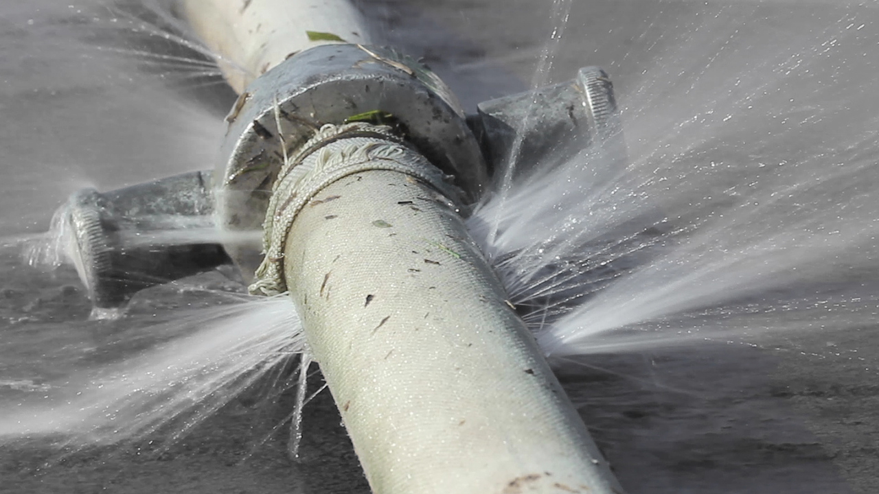 Burst water pipe spraying pressurized water
